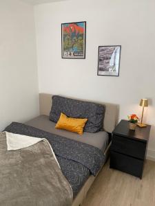 ein kleines Zimmer mit einem Bett und einem Nachttisch in der Unterkunft Appartement au cœur de la Riviera in Montreux