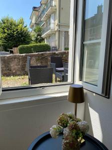 einen Tisch mit einer Lampe und einer Blumenvase in der Unterkunft Appartement au cœur de la Riviera in Montreux