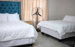 a hotel room with two beds and a fan at LESEGO LA RONA Villa in Manamakgoteng