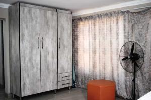 a bedroom with a large cabinet and a fan at LESEGO LA RONA Villa in Manamakgoteng