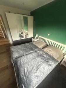 a large bed in a bedroom with a green wall at Ferienwohnung Weber in Bergen