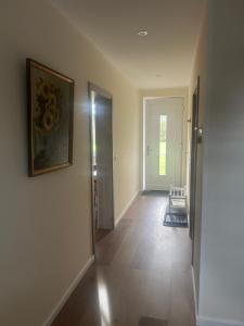 an empty hallway with a painting on the wall and a door at Ferienwohnung Weber in Bergen +8 photos