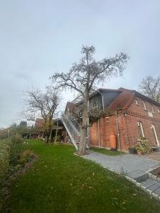 a brick building with a tree and a staircase at Ferienwohnung Weber in Bergen