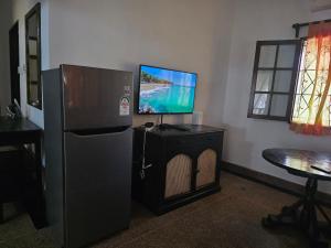 een woonkamer met een koelkast en een televisie bij Karibuni, Villa 107, Beachfront Stay with Restaurant, Pool & Bar in Malindi