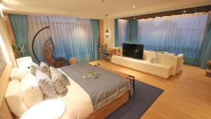 a bedroom with a bed and a television in a room at Hando • Cape Seven Seaside Villa in Qingdao