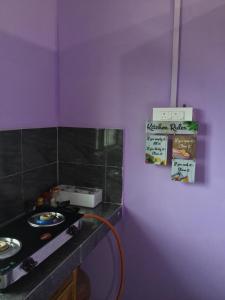 una cocina con fogones y un cartel en la pared en Niroda Guest House, Jorhat, en Jorhat 12 fotos más