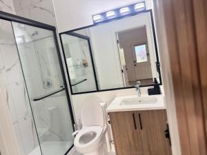 Un baño con inodoro, ducha y lavabo. en Walkout basement suite with canal view near airport, en Airdrie 16 fotos más