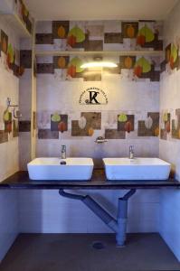 two sinks in a bathroom with a clock on the wall at Royal Serene Villas in Ooty