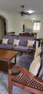 a living room with couches and tables in a room at Diani Airport View Apartments in Diani Beach