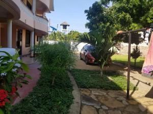 a car parked in the driveway of a house at Diani Airport View Apartments in Diani Beach