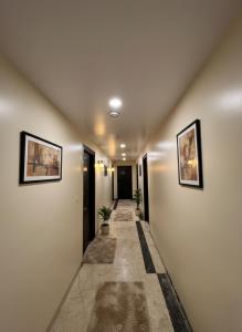 a long hallway with two pictures on the walls at Hotel Heaven Luxes Opp Miraj Cinemas in Hyderabad +19 photos