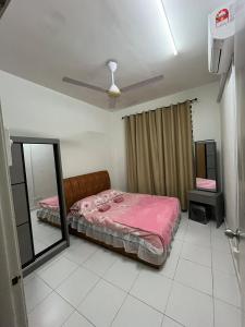 a bedroom with a pink bed and a mirror at Dua Puteri Homestay 