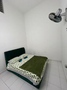 a bedroom with a bed with a green blanket on it at Dua Puteri Homestay 