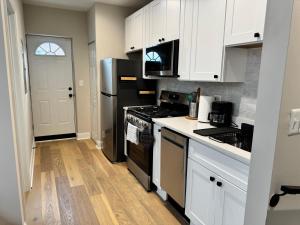 een keuken met witte kasten en zwarte apparaten bij Villa del Encanto in Washington