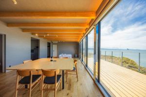 een eetkamer met een tafel en uitzicht op de oceaan bij Yunagi 夕凪 