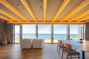 een eetkamer met een tafel en stoelen en de oceaan bij Yunagi 夕凪 