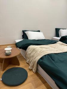 ソウルにあるSodamjae Stay, near Seokchon Lake 5 guestsのベッドルーム1室(緑のシーツとテーブル付)