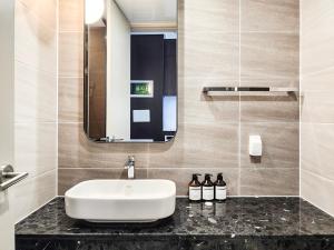 a bathroom with a white sink and a mirror at Paramion Hotel in Busan +53 photos