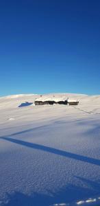 a building in the middle of a sand field at Renovated Mountain Cabin With Cross Country Trails in Granheim