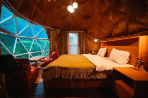a bedroom with a bed and a large window at Pelaga Eco Park in Patjung +21 photos