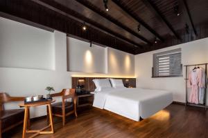 Schlafzimmer mit einem weißen Bett, einem Tisch und einem Schreibtisch in der Unterkunft Golden Dragon's Mountain Glow Inn Chinese Style Courtyard of Lijiang Ancient Town English Speaking Service Close to main streets near by Dashiqiao Sifang Street,Big Water Wheels We offer private car service,tickets purchasing services in Lijiang