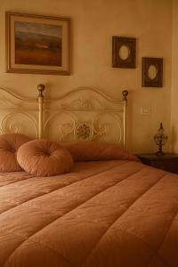 a bedroom with a large bed with an orange pillow at La Locanda Del Tevere in Fiano Romano