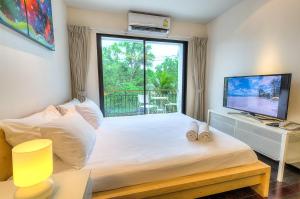 Un dormitorio con una cama y una ventana grande en The Title Comfort Condotel, en Rawai Beach 67 fotos más