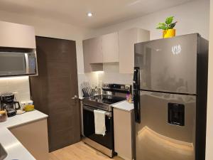 una cucina con frigorifero in acciaio inox e fornello di Penthouse entre nubes y volcanes a Quetzaltenango