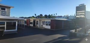 a building with a sign in front of a motel at Waikato Hospital Motel in Hamilton