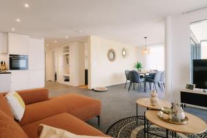 ein Wohnzimmer mit Sofa und Tisch in der Unterkunft Apartment Stockhorn in See- und Bergnähe, modern, mit Balkon, 4 Gäste in Einigen