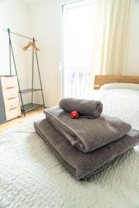 ein Schlafzimmer mit einem Bett mit Handtüchern darauf in der Unterkunft Apartment Stockhorn in See- und Bergnähe, modern, mit Balkon, 4 Gäste in Einigen