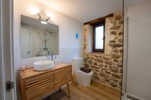 a bathroom with a sink and a stone wall at The Stone House naturaleza y confort in Santibáñez de Villacarriedo +40 photos