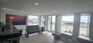 a living room with a green chair and windows at Hotel Playamar in Mazatlán