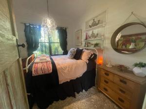 - une chambre avec un lit, un miroir et une commode dans l'établissement PET Friendly Miners Cottage 'Baraka BnB', à Kalorama