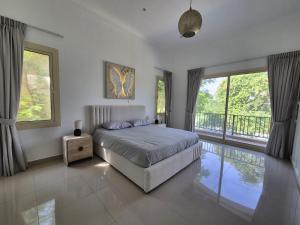 a bedroom with a bed and a large window at Élégante Villa de Luxe 5 Chambres avec Piscine Privée in Dubai