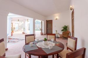 una sala da pranzo con tavolo e sedie di amã Stays & Trails Isley, Dhauj Haryana a Dhauj