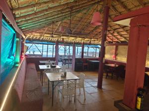 a restaurant with tables and chairs in a room at Jasmine Beach Resort in Morjim