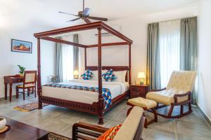 una camera da letto con letto a baldacchino e scrivania di amã Stays & Trails Isley, Dhauj Haryana a Dhauj