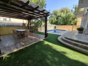 a backyard with a table and a swimming pool at Élégante Villa de Luxe 5 Chambres avec Piscine Privée in Dubai
