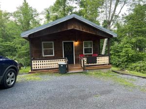 ein winziges Haus mit einer Veranda und zwei Bänken in der Unterkunft Bitter Goose Cabin in Barnettstown