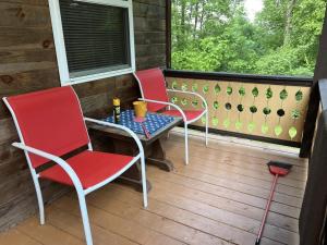 eine Veranda mit 2 Stühlen, einem Tisch und einem Fenster in der Unterkunft Bitter Goose Cabin in Barnettstown