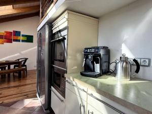 a kitchen with a refrigerator and a coffee maker on a counter at HolidayHome Apartments|Luxury Loft-Style Apartment in Brandenburger Vorstadt