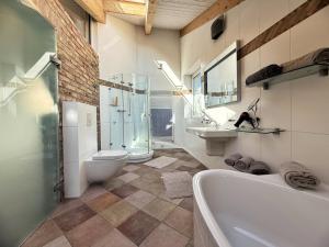 a bathroom with a tub and a toilet and a sink at HolidayHome Apartments|Luxury Loft-Style Apartment in Brandenburger Vorstadt