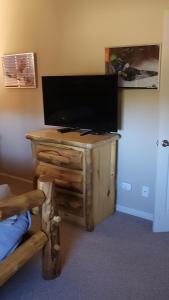 TV de pantalla plana sobre una mesa de madera en Meadow Ridge Mountain Views 8 minutes from Basecamp, en Maryvale