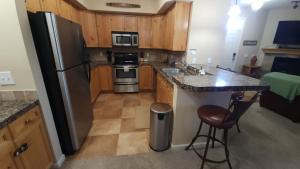 Una cocina con gabinetes de madera y un refrigerador de acero inoxidable. en Meadow Ridge Mountain Views 8 minutes from Basecamp, en Maryvale 16 fotos más