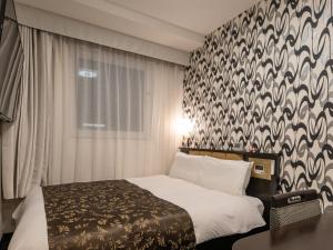 Ένα ή περισσότερα κρεβάτια σε δωμάτιο στο APA Hotel Nagoya Ekimae Kita