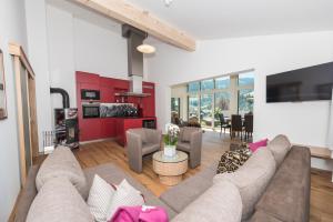 a living room with a couch and a kitchen at Luxusapartment Müllerhaus in Mühlbach am Hochkönig