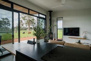 a living room with a couch and a large window at 8 Paddocks Chalet Two in Cowaramup