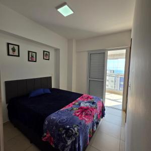 a bedroom with a bed and a window with a view at Encontro marcado in Praia Grande