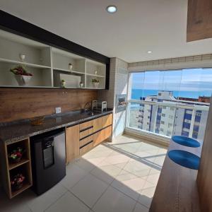 a kitchen with a balcony with a view of the ocean at Encontro marcado in Praia Grande +76 photos
